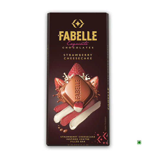 The Fabelle Strawberry Cheesecake Milk Bar 131g boasts artful packaging with chocolate, strawberries, and cream against a dark background. Originating from India, it captures the rich flavors and vibrant essence of its Country of Origin.