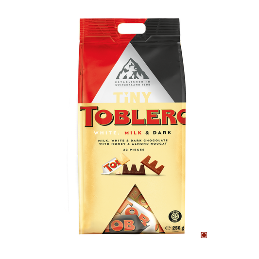 A Toblerone Tiny Mix Bag 256g of tiny Toblerone chocolates featuring white, milk, and dark chocolate varieties with honey and almond nougat, displaying 32 pieces and a weight of 256 grams.