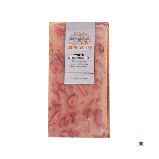 A wrapped bar of Rhine Valley White Strawberry Bar 100g with pieces of dried strawberries embedded in the chocolate. The clear packaging shows the product inside, while the text details product info and Country of Origin: India.