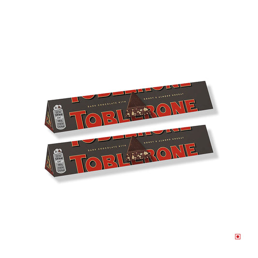 Two Toblerone Dark Chocolate Pack of 2 (100g x 2) bars are displayed on a white background, featuring the brand’s iconic triangular packaging and classic Swiss chocolate appeal.