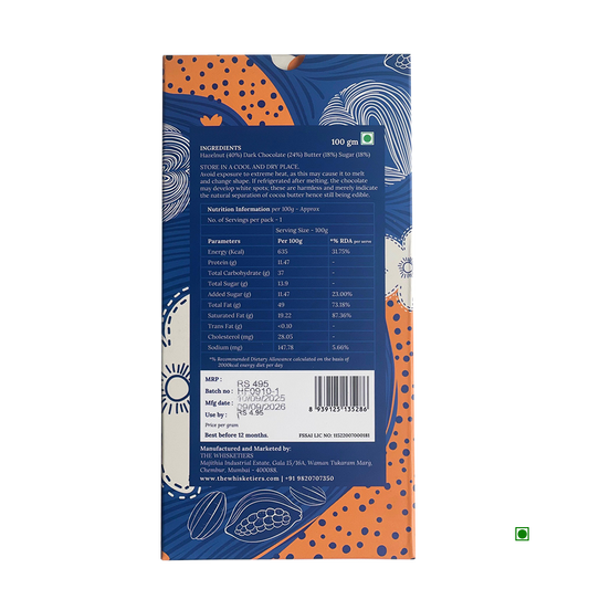 Back of The Whisketiers Hazelnut Dark Chocolate 100g bar by Whisketiers, showing ingredients like caramelised hazelnuts and dark chocolate, nutrition facts, price, manufacturer info, and storage advice on a blue and orange patterned background.