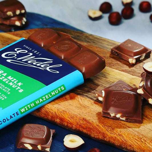 A Wedel Extra Milk Chocolate With Hazelnuts Bar 80g on a cutting board.