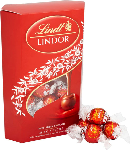 The Lindt Lindor Chocolate Cornet Milk 337g, in its striking red packaging, elegantly highlights the fine craftsmanship of Lindt chocolatiers, accompanied by three generously wrapped milk chocolate truffles placed gently nearby.