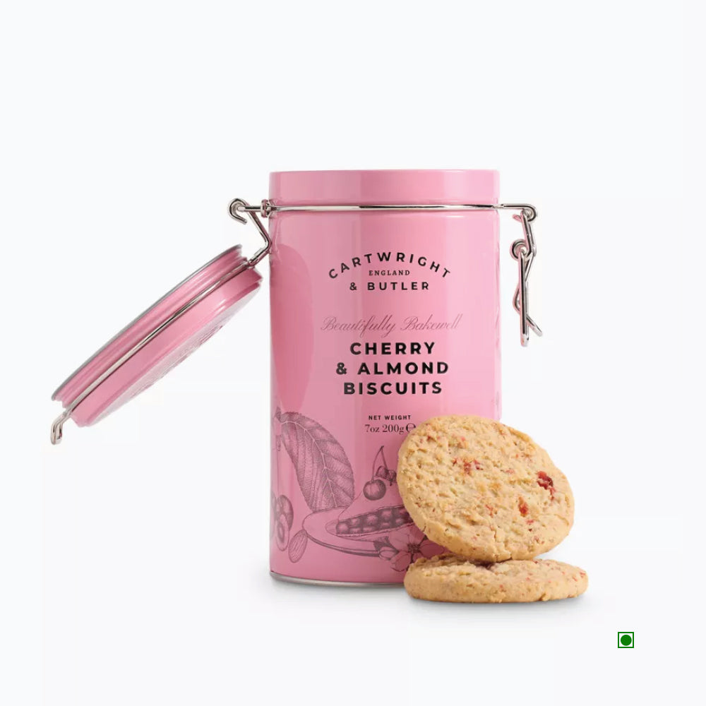 A 200g pink tin of Cartwright & Butler Cherry & Almond Biscuits, showcasing two buttery biscuits in front, enhanced with cherries and made from premium ground almonds.