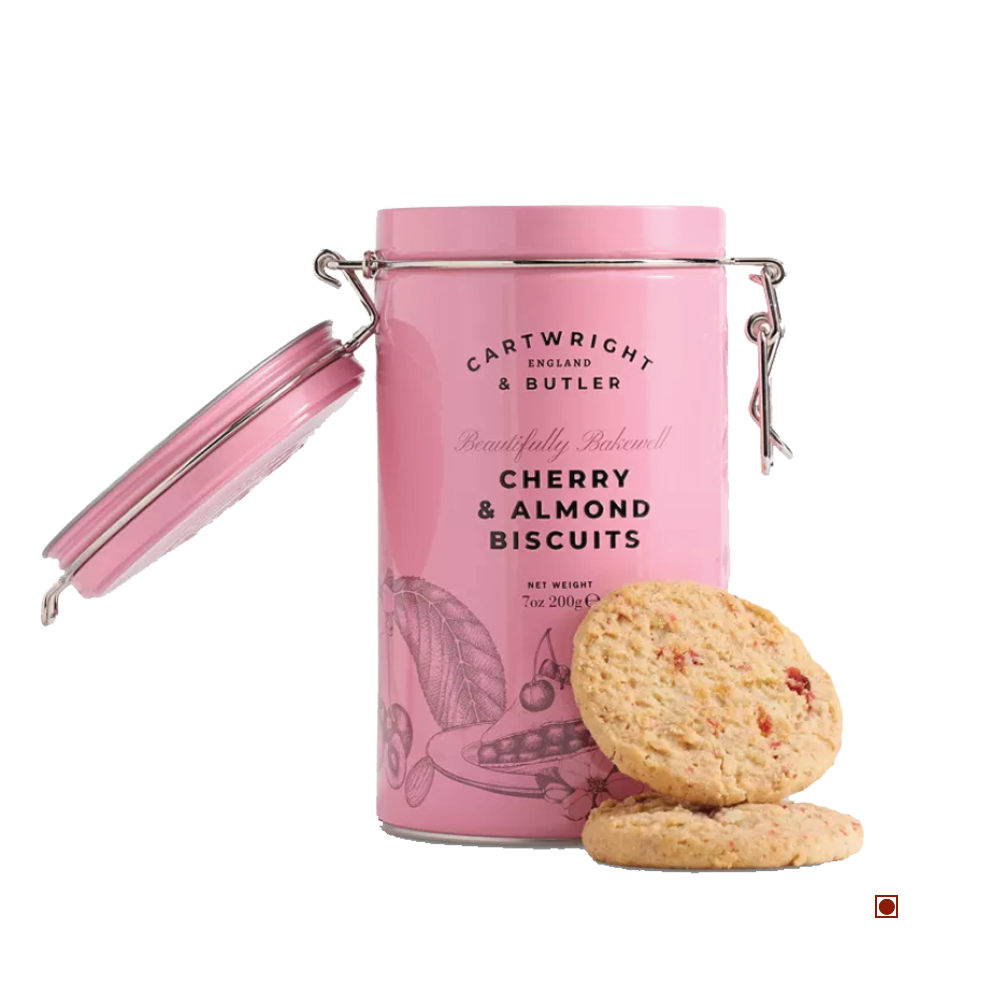 A pink Cartwright & Butler Cherry & Almond Biscuits Tin 200g sits open, with two buttery biscuits featuring ground almonds and glazed cherries displayed beside it on a white background.