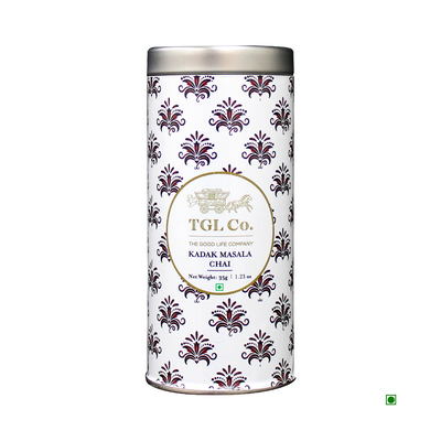 A cylindrical tin with a white and purple damask design, labeled "Cococart India Kadak Masala Chai," containing 150 grams of TGL Co. Indian Chai.