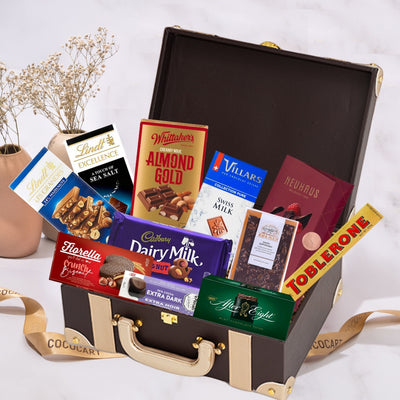 A brown suitcase filled with the Ultimate Treasure Chest chocolates from Gift Hampers.