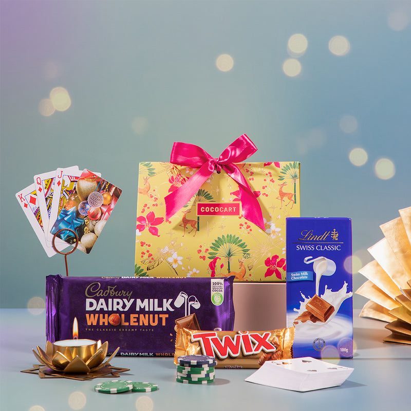 A Diwali-themed gift basket filled with decadent chocolates and curated CocoCart items, elegantly displayed on a table. 

Revised Sentence: The Rummy Festive Pyramid gift basket filled with decadent chocolates and curated CocoCart items, elegantly displayed on a table.