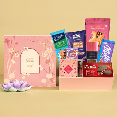 A pink box filled with Chic Treats- Sakura Hamper, cookies, and other snacks.