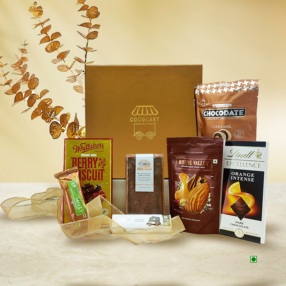 The Festive Opulence Hamper by Gift Hampers offers a delightful assortment of indulgences, including Lindt, Whittaker's, and Chocodate chocolate bars, all beautifully organized with a decorative gold ribbon and dried leaves to add a touch of sophistication.