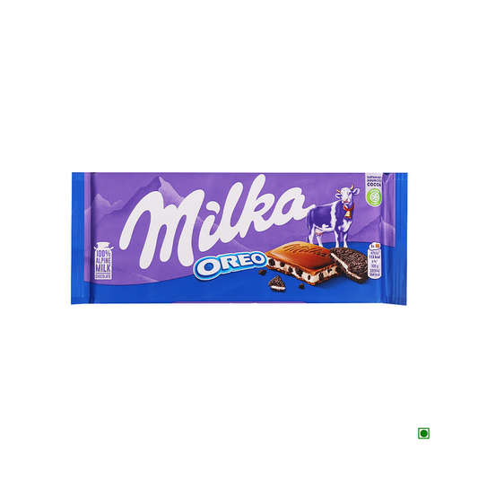 A Milka Oreo Milk Chocolate Bar 100g with purple packaging, featuring an image of a chocolate piece with OREO cookies filling. Branding elements include a cow illustration and the "100% Alpine Milk" label, making this European candy a delightful treat for Milka chocolate enthusiasts.