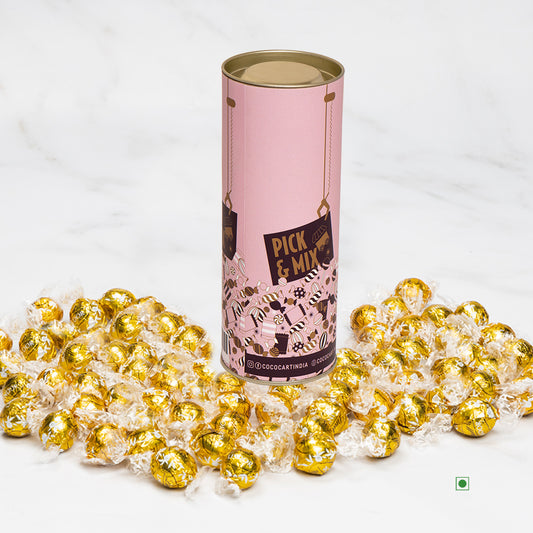 A tin of Pick & Mix : Lindor White 100/250/500g candies on a marble table.