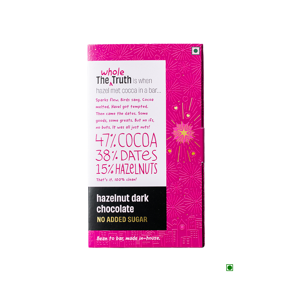 A bar of The Whole Truth Hazelnut Dark Chocolate 90g with a pink background.