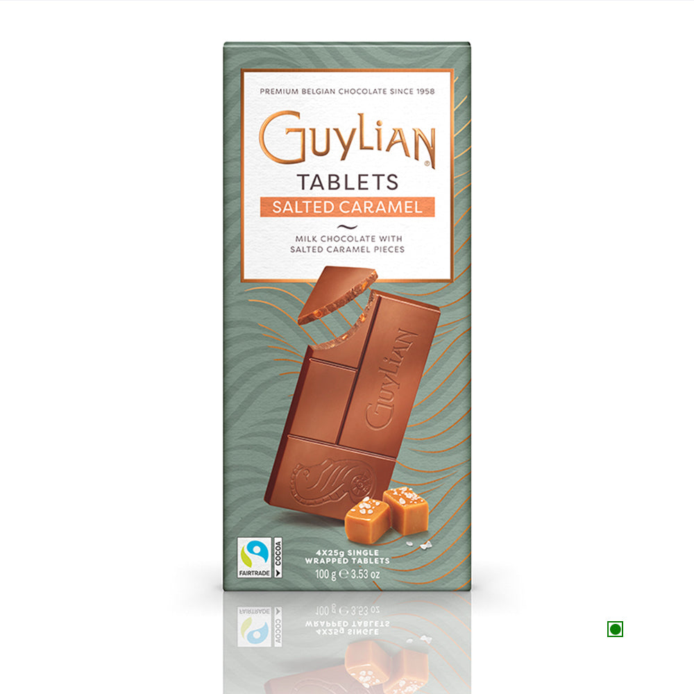 The Guylian Salted Caramel Milk Chocolate Tablet 100g, a product of the esteemed Guylian brand, boasts elegant packaging adorned with the Fairtrade logo. Made in Belgium, this chocolate bar is partially unwrapped to reveal its creamy milk chocolate and luxurious caramel pieces, highlighting its exquisite Belgian craftsmanship.