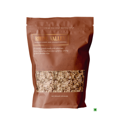 A bag of Rhine Valley Hazelnut Honey Dark Granola 225g on a white background, perfect for snacking.