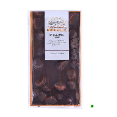 A freshly roasted Rhine Valley Macadamia Dark 100g chocolate bar with Australian macadamias in a package on a white background.