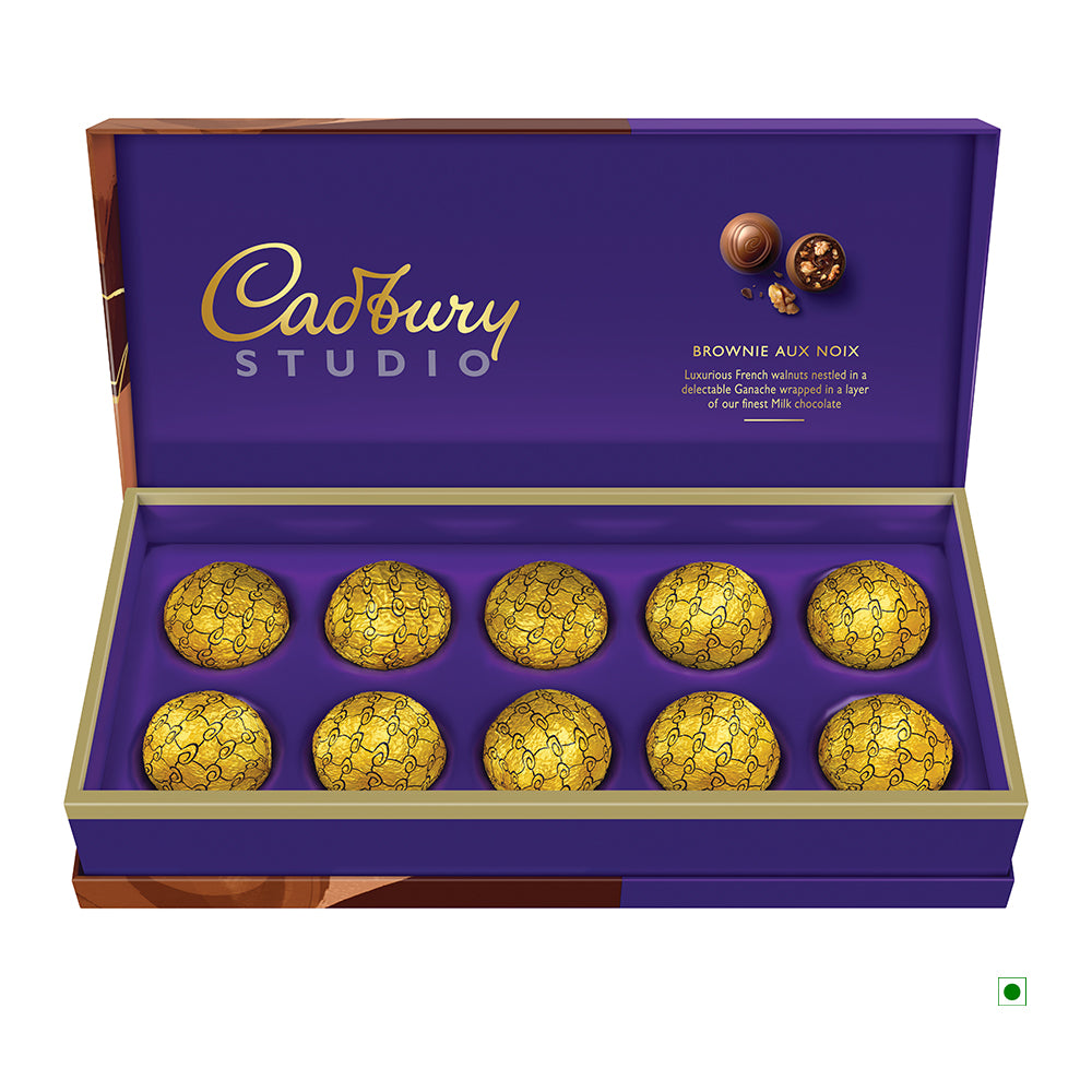 A Cadbury Brownie 130g box from India, featuring a purple and gold design, contains ten round pralines wrapped in gold foil.