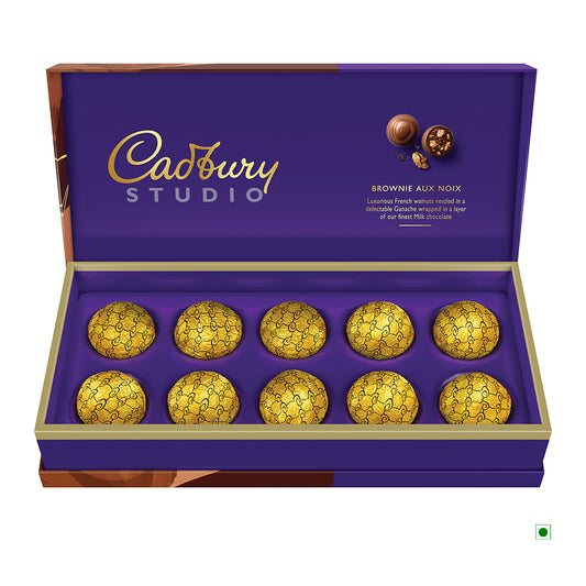 A Cadbury Brownie 130g box from India, featuring a purple and gold design, contains ten round pralines wrapped in gold foil.