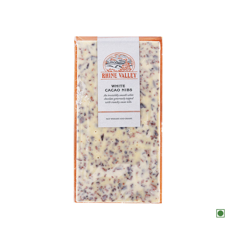 A package of Rhine Valley White Chocolate with Crunchy Cocoa Nibs 100g bar labeled "Country of Origin: India," isolated on a white background.