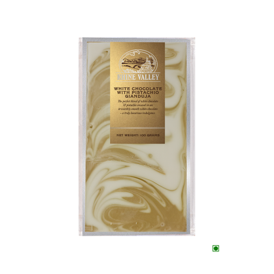 A bar of Rhine Valley white chocolate with pistachio gianduja swirls, packaged in a box labeled "Rhine Valley luxurious white chocolate with ganache," net weight 100 grams.
