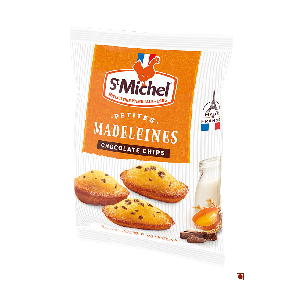 A package of St Michel Mini Madeleines Sponge Cake with Choco Chip Bag 75G, featuring images of madeleines, a glass of milk, honey, and chocolate pieces. The label proudly states the product is made in France, celebrating the classic vanilla Madeleine cake infused with delightful chocolate chips.