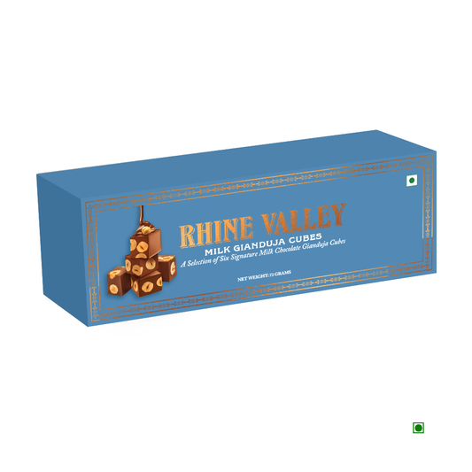 A blue box labeled "Rhine Valley Gianduja Cubes Milk (6 Pcs) 72g," adorned with an image of delectable chocolate cubes, prominently displays India as its country of origin.