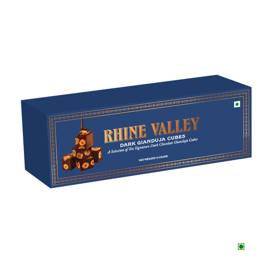 A blue box with gold accents contains Rhine Valley Gianduja Cubes Dark chocolates, meticulously crafted. The country of origin is subtly marked, enhancing the allure of this exquisite 72g selection.