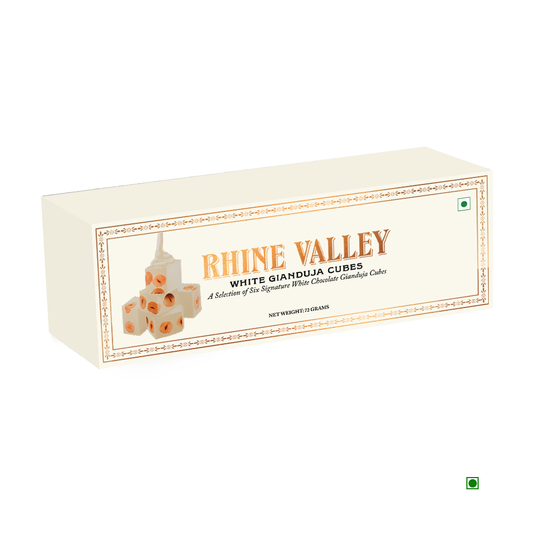 A package of Rhine Valley Gianduja Cubes White (6 Pcs, 72g) features an image of cube-shaped chocolates on the front and highlights its country of origin: India.