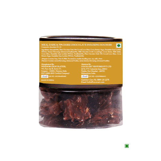 A jar labeled "Rhine Valley New Snacking Rochers Assorted 200g" with visible chocolate clusters inside. The label includes a detailed ingredient list, manufacturing, and contact information.