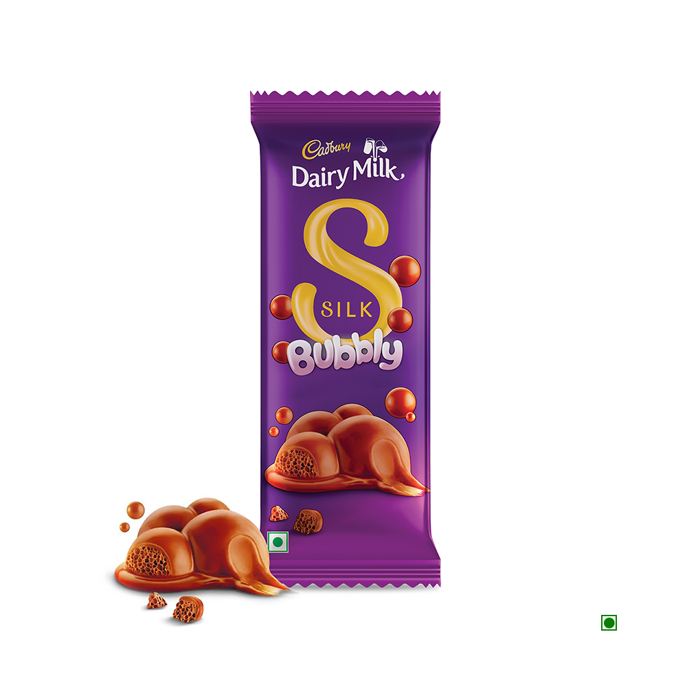 The Cadbury Dairy Milk Silk Bubbly Chocolate Bar 50g, recognized by its distinctive purple packaging with bubble designs, is made with creamy milk chocolate and cocoa sourced sustainably. The bar is accompanied by pieces of this exquisite chocolate.