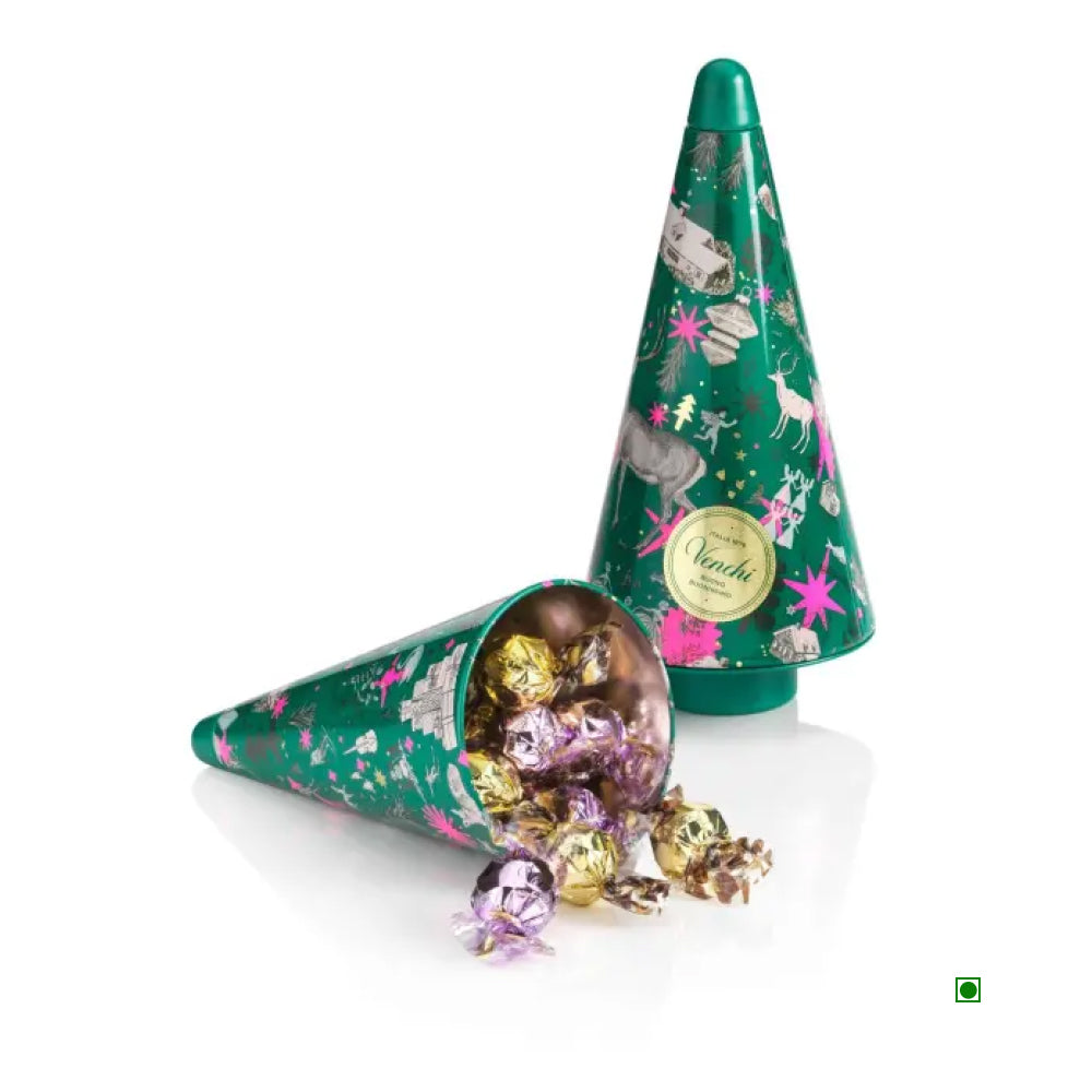 Two green, cone-shaped Venchi Christmas Anna Higgie Pine Metal Tins, one open and spilling wrapped hazelnut pearls.