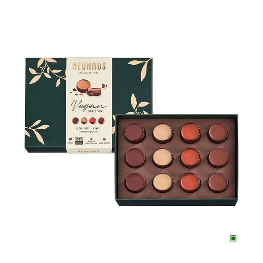 An open-top box of the Neuhaus Vegan Chocolate Collection 120g showcases a variety of round chocolates. The packaging is dark green adorned with gold leaf designs, reflecting the elegance of classic Belgian praline craftsmanship associated with Neuhaus.