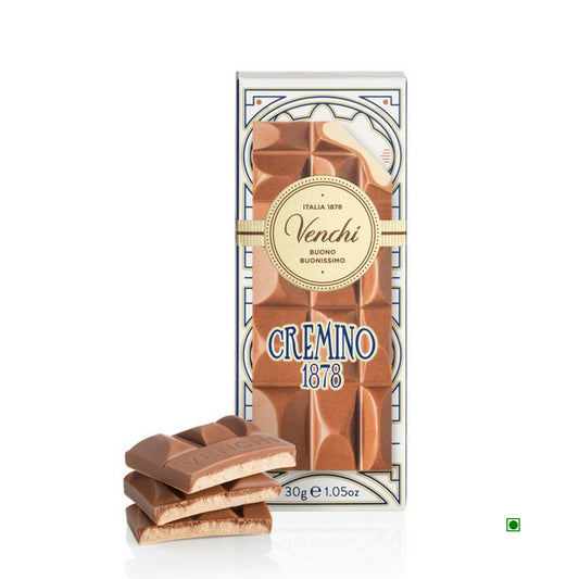 The Venchi Mini Cremino Chocolate Bar 30g, with broken sections in front of the package, highlights the creamy delight of Piedmont Hazelnuts.