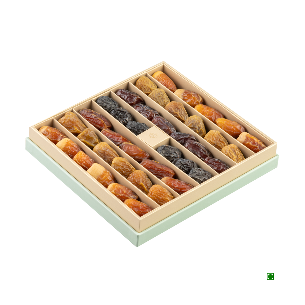 A square Nua Luxury Nakheel Mint Gift Box 500g, featuring an assortment of dried fruits organized in rows within individual slots, proudly showcasing their country of origin, Saudi Arabia.