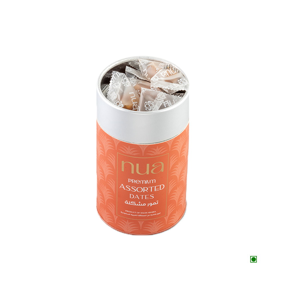 An orange, cylindrical container adorned with a palm leaf pattern and labeled "Nua Mixed Dates Cylinder 400g" contains individually wrapped dates. It prominently displays the brand name Nua and indicates that the product originates from Saudi Arabia.