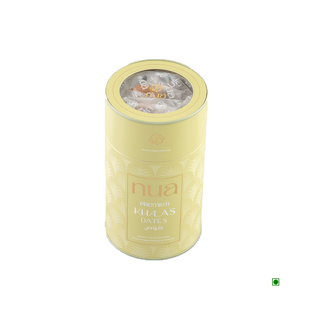 A cylindrical beige tin with a clear top containing "Nua Khalas Dates Cylinder 400g." The tin, proudly displaying its country of origin, Saudi Arabia, features text in both English and Arabic and has a small green checkmark logo on the bottom right.