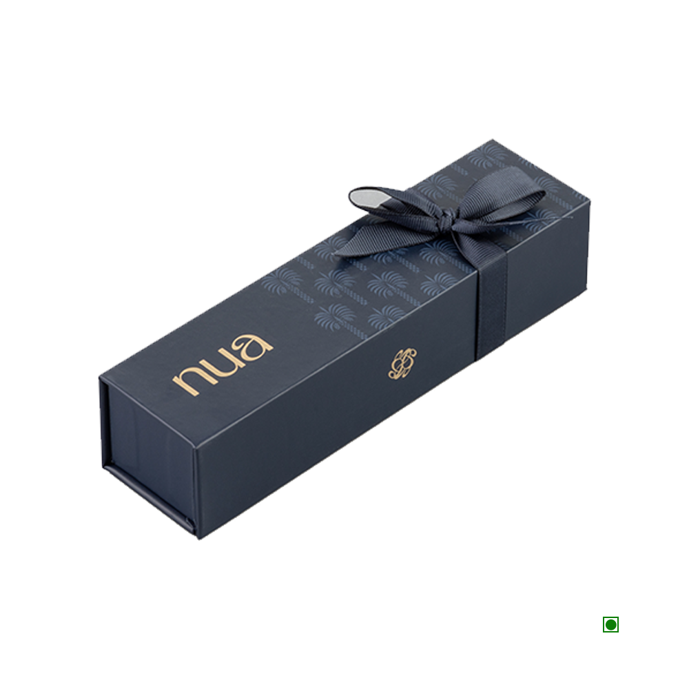 A rectangular black gift box with a bow on top, featuring "Nua" written in gold on the side, meticulously crafted as the Nua Small Gift Box Navy Fronds 100g from Saudi Arabia.