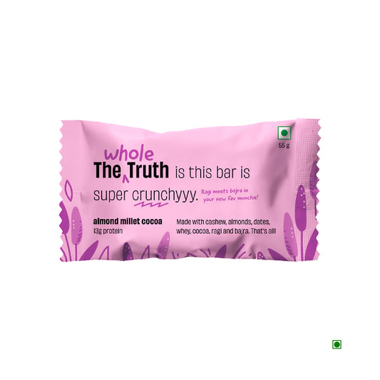 A colorful pink and purple package features "The Whole Truth Almond Millet Cocoa Protein Bar 55g," highlighting its rich blend of ingredients like almonds and chocolate for extra crunch in the almond millet cocoa flavor.