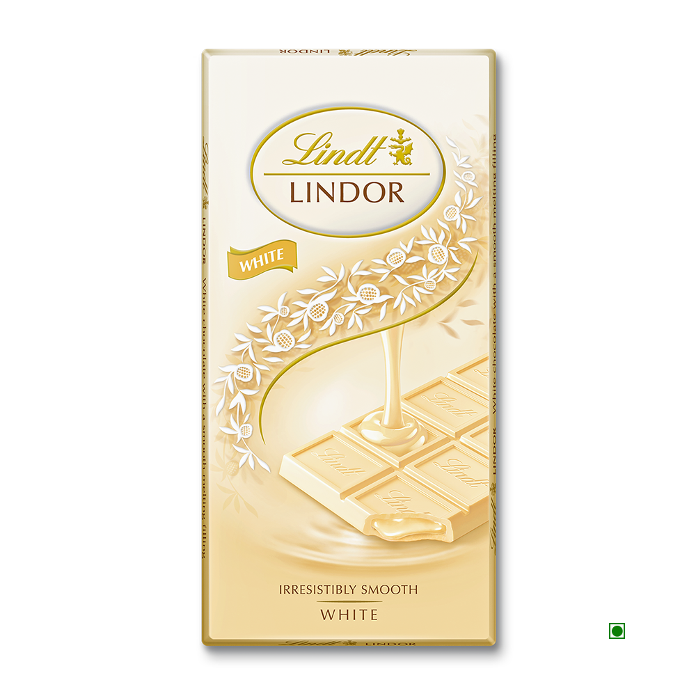 Lindt Lindor White Tablet 100g packaging by Lindt shows white chocolate poured over squares, adorned with floral designs and gold accents.