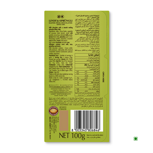 Back of a Lindt Lindor Pistachio Tablet 100g bar in green packaging, showing ingredients with pistachio, nutrition information, barcode, and quality guarantee text in English and Arabic.