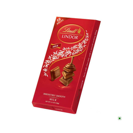 A 100g Lindt Lindor Singles Milk Bar, crafted with the finest LINDT milk chocolate from SWITZERLAND. The packaging showcases a smooth and enticing depiction of the milk chocolate bar.