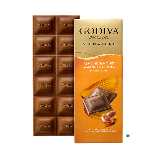 The Godiva Milk Honey Almond Bar 90g, crafted by the renowned brand Godiva, offers a delightful combination of milk chocolate infused with roasted almonds and honey, beautifully packaged with enticing images of chocolate pieces and almonds.