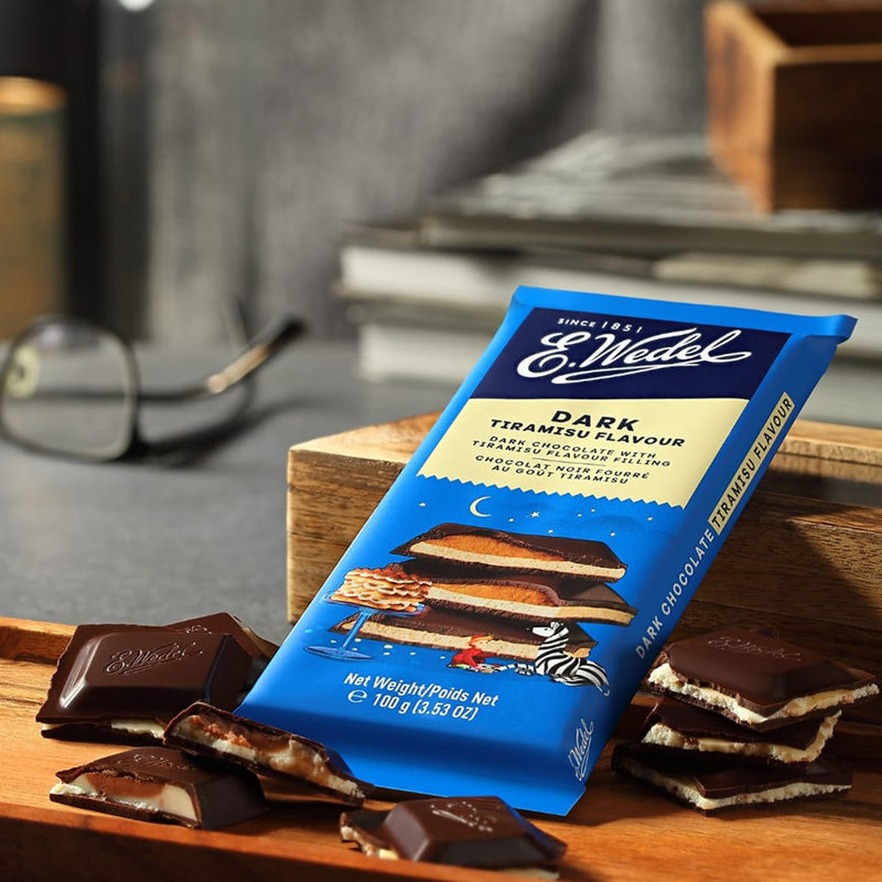 A Wedel Dark Chocolate With Tiramisu Filling Bar 100g sitting on top of a cutting board.