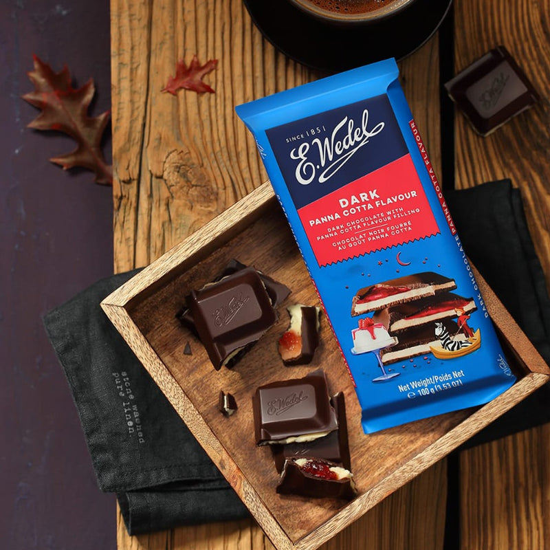 Wedel Dark Chocolate With Panna Cotta Filling Bar 100g in a wooden box next to a cup of coffee.