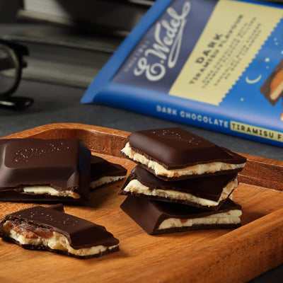 Wedel Dark Chocolate With Tiramisu Filling Bars 100g on a cutting board next to a package of Wedel.