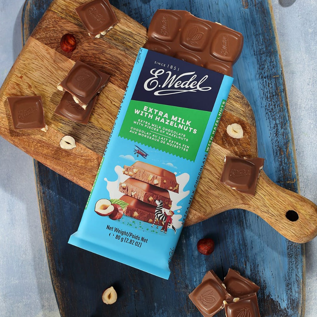 A Wedel Extra Milk Chocolate With Hazelnuts Bar 80g on a cutting board.