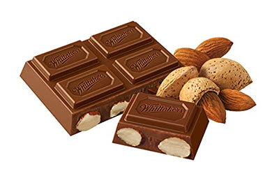 A Whittakers Almond Gold Bar 250g with almonds and nuts on a white background.
