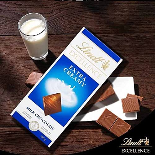 A Lindt Excellence Extra Creamy Bar 100g with a glass of milk next to it.