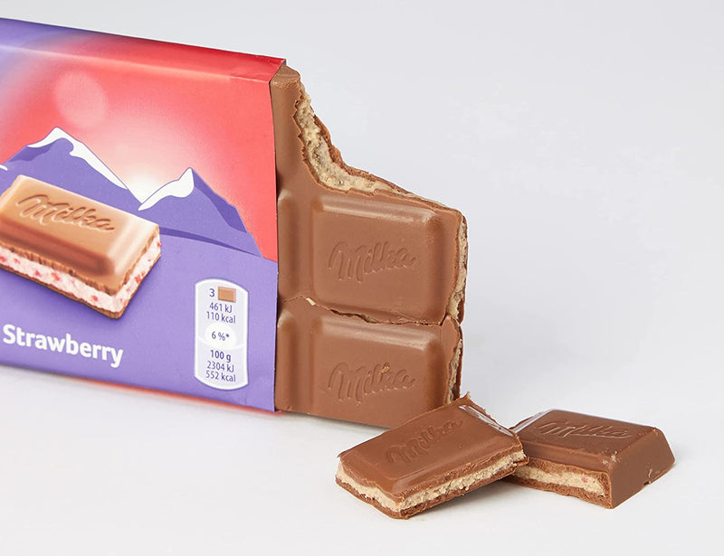 A Milka Strawberry Milk Chocolate Bar 100g with a piece of chocolate next to it.
