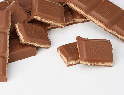 A group of Milka Strawberry Milk Chocolate Bars 100g on a white surface.